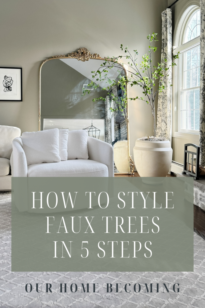 Living room with white chair, faux tree in planter and mirror with caption of how to style faux trees in 5 steps.