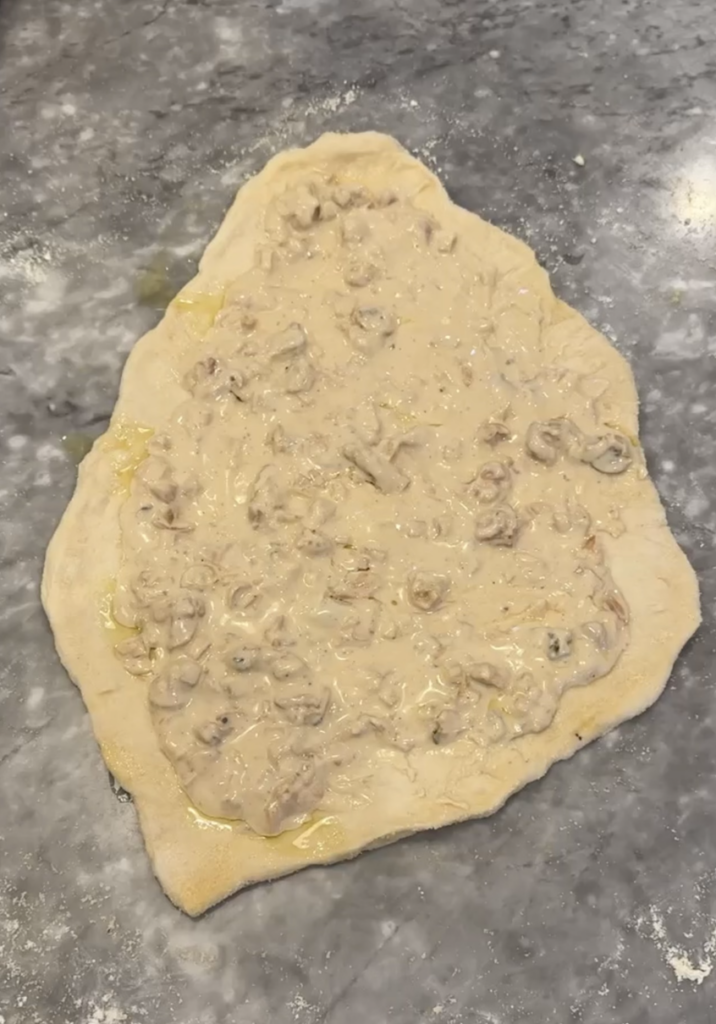 Clam sauce spread on top of pizza dough.