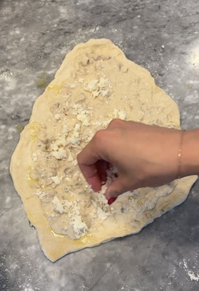 Cheese sprinkled on top of white clam pizza.