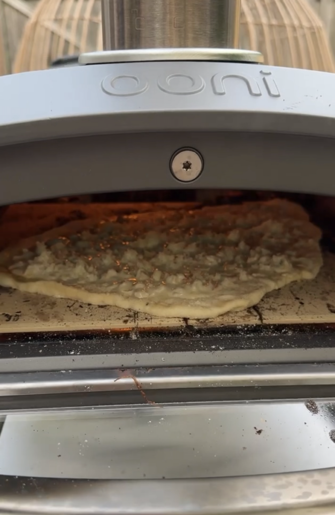 White clam pizza inside Ooni pizza oven.