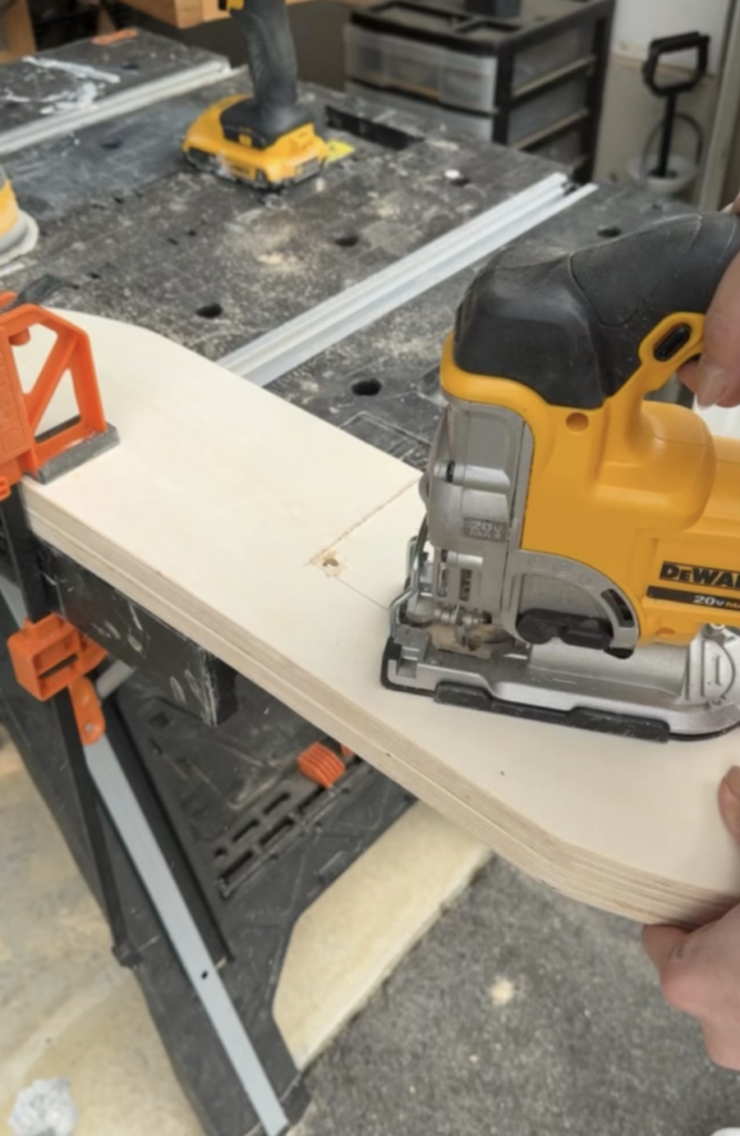 Plywood being cut with an up close image of a jigsaw.